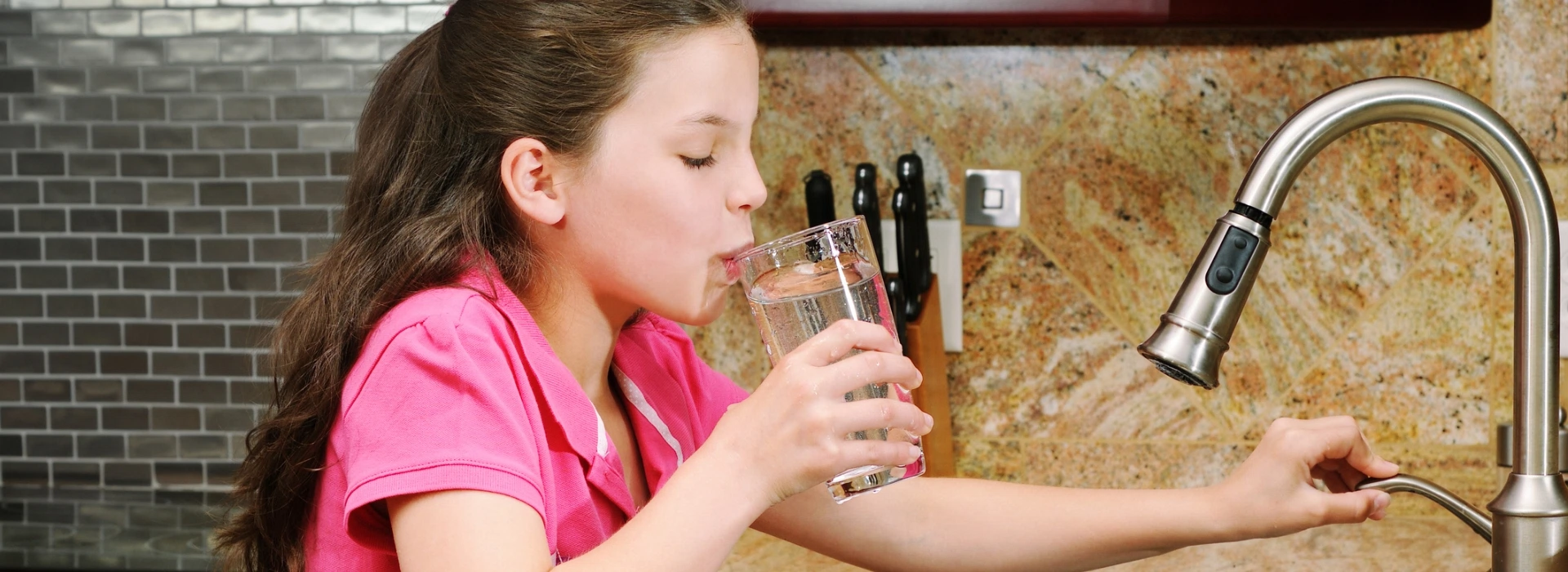dziewczynka pijąca wodę z kranu